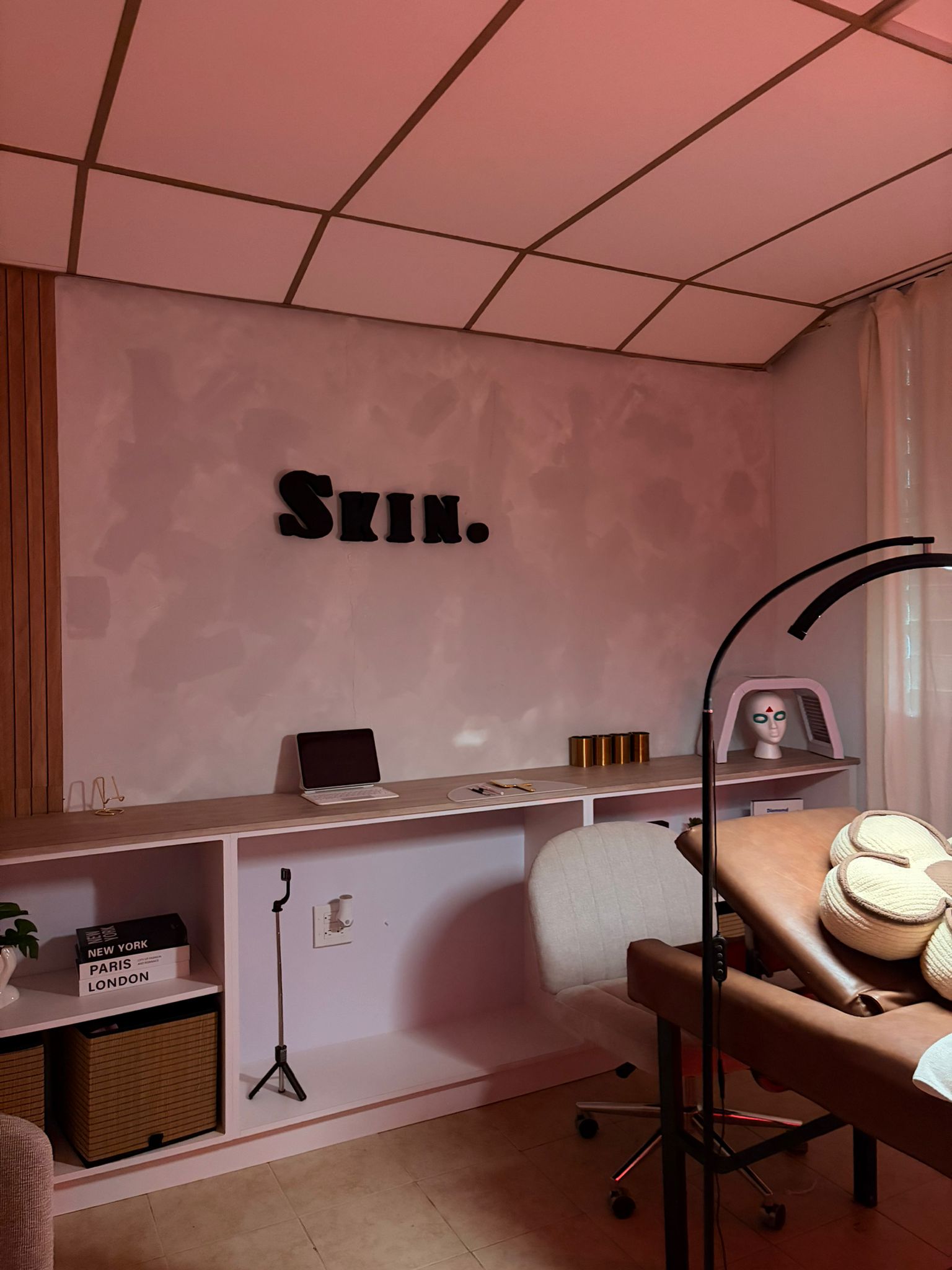 The Skin By Leudy treatment studio in soft blush light with the Skin. signage