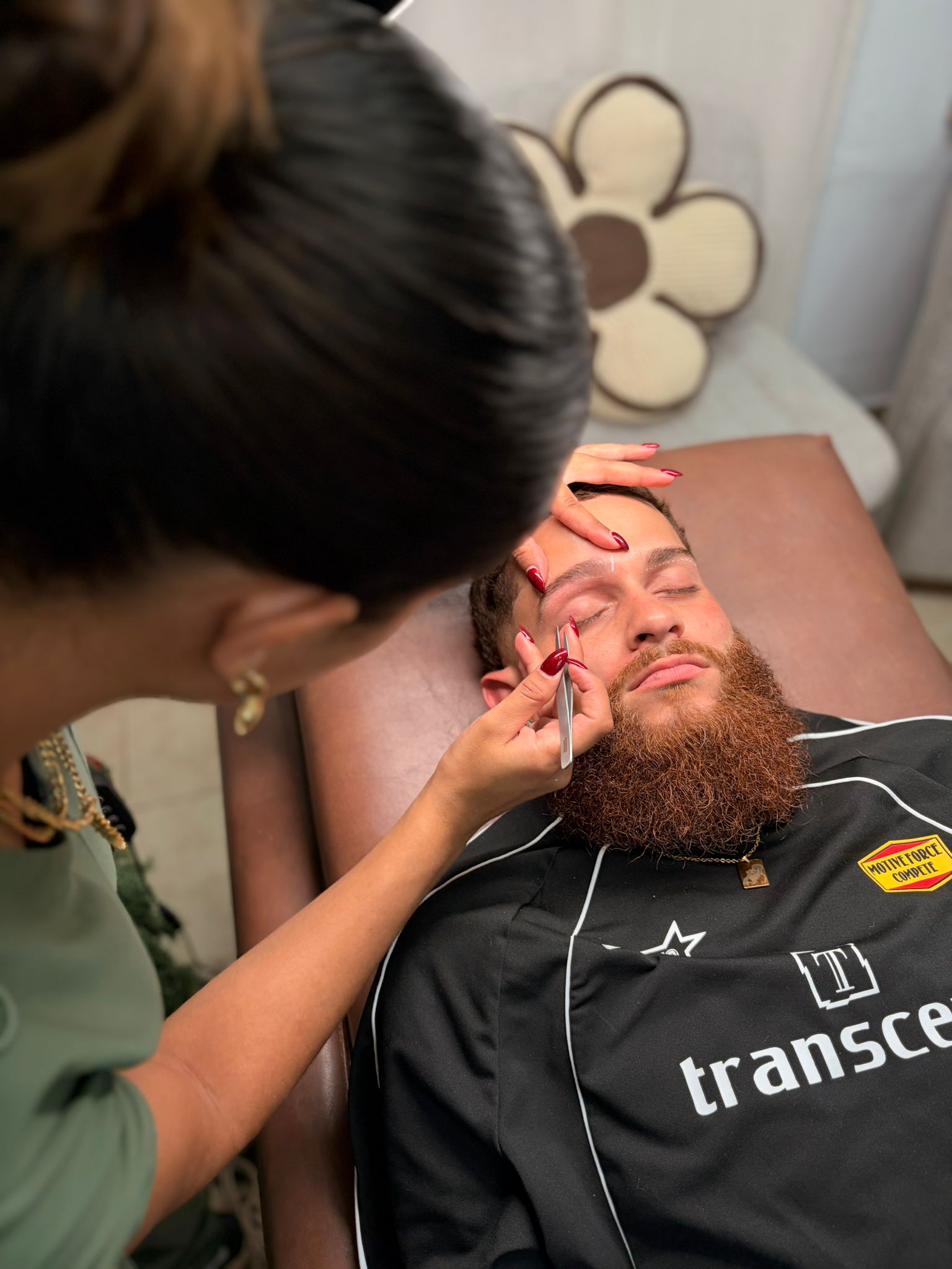 Leudy shaping a client's brows during a treatment